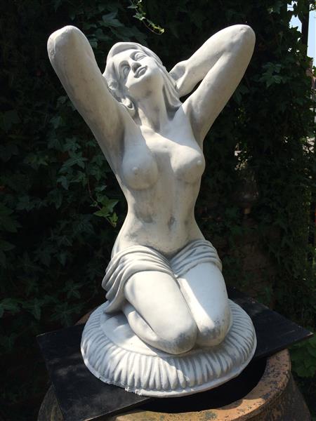Grote foto mooi vol stenen beeld van een naakte knielende vrouw heel fraai tuin en terras tuindecoratie