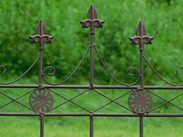 Grote foto hekwerk met franse lelies smeedijzer donkerbruin sierhek tuin en terras tuindecoratie